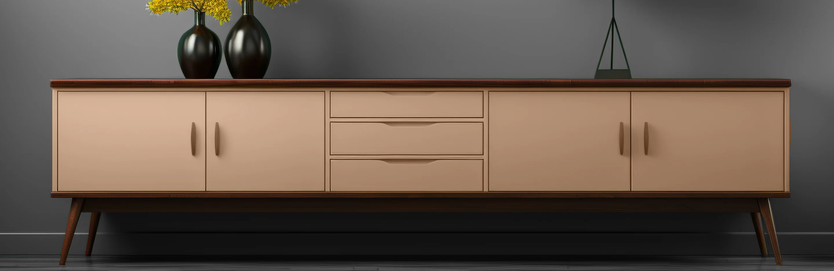 A beige wooden console table with colored finish placed against a grey wall.