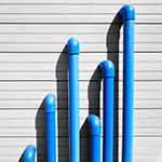 Blue plastic pipes on a grey wall.