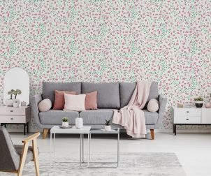 Pink blanket and cushions on grey settee in white flat interior with poster above cupboard. Real photo