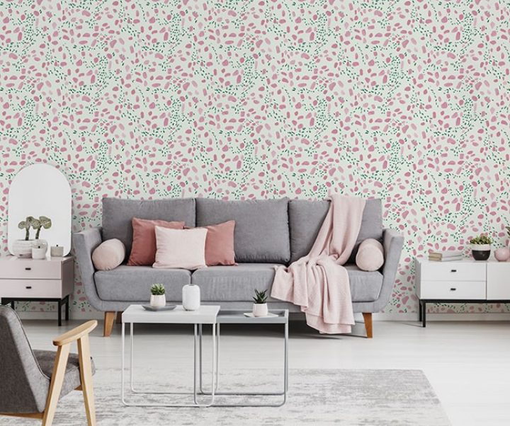 Pink blanket and cushions on grey settee in white flat interior with poster above cupboard. Real photo Pink blanket and cushions on grey settee in white flat interior with poster above cupboard. Real photo
