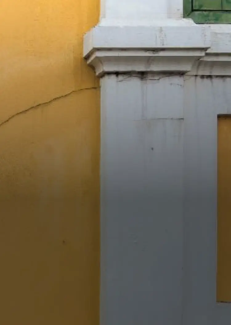 Cracks shown on a yellow exterior wall