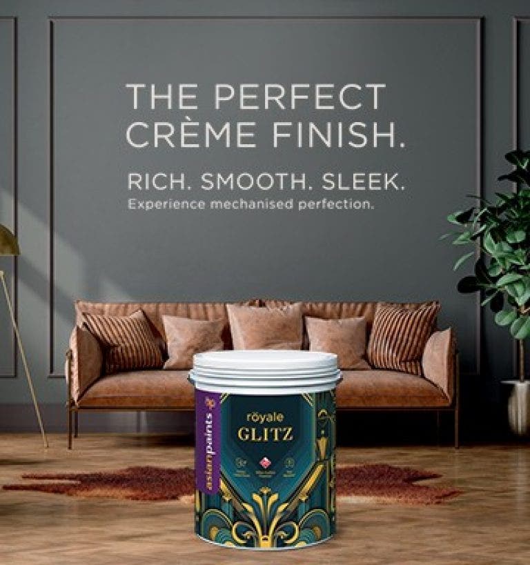 Banner image of a crème finish sofa with gold accents and grey wall