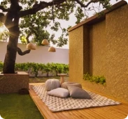 Garden deck with floor cushions next to a golden wall in Apex Ultima Allura stone texture