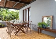 Covered veranda with a wooden dining table beside a grey wall in Apex Ultima Allura stone texture