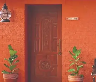 Orange brick-look exterior wall in Apex Createx texture with a carved wooden door